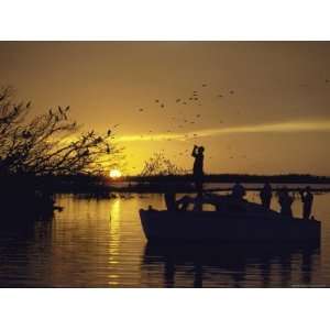 Silhouettes of People in Boat at Sunrise Bird watching in Everglades 