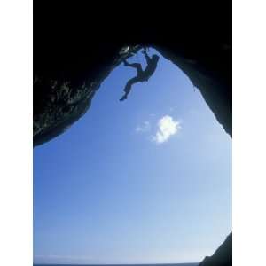 Climber Ascending a Cave Archway at Foxhole, Gower Peninsula, Wales 